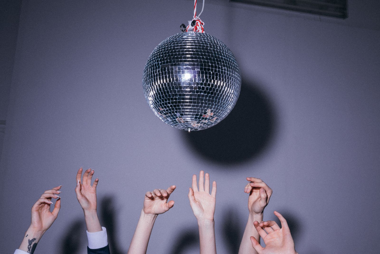 Gasten in feestkleding zingen karaoke onder discolicht